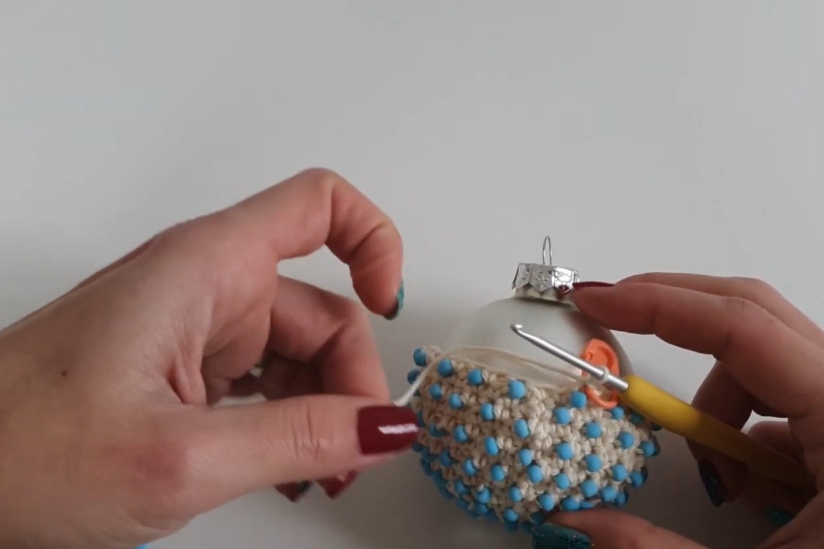 Crocheting the beaded cover around a glass Christmas bauble