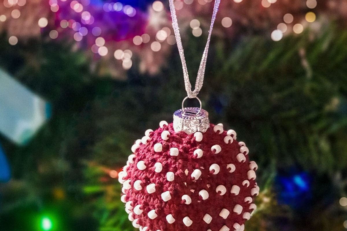 Red beaded crochet Christmas bauble hanging on the tree by ByKaterina Designs