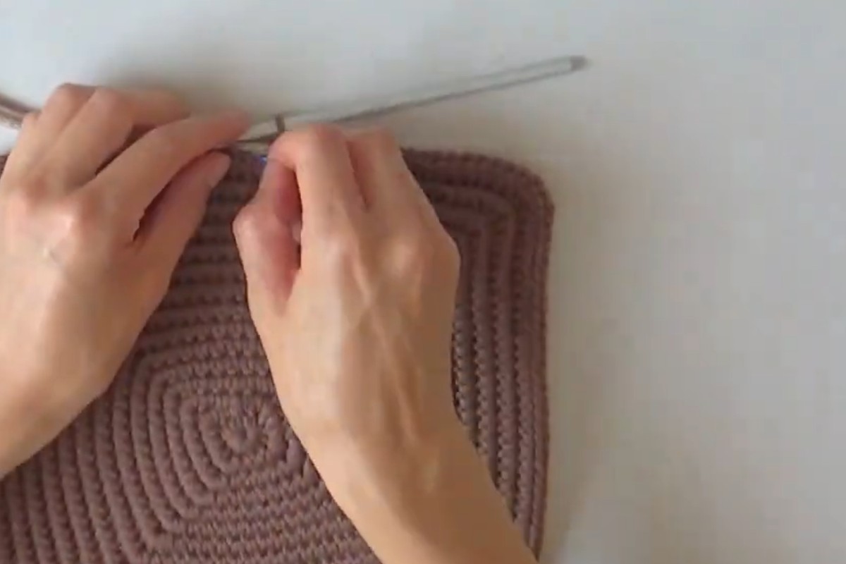 Square base of the bicolor crochet basket worked over cord
