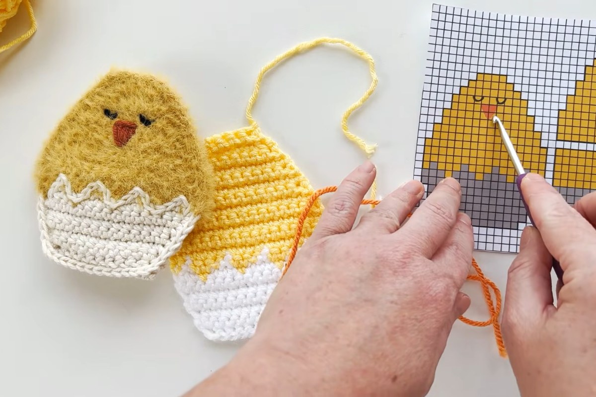 Embroidering the beak on the front piece of the crochet chick egg