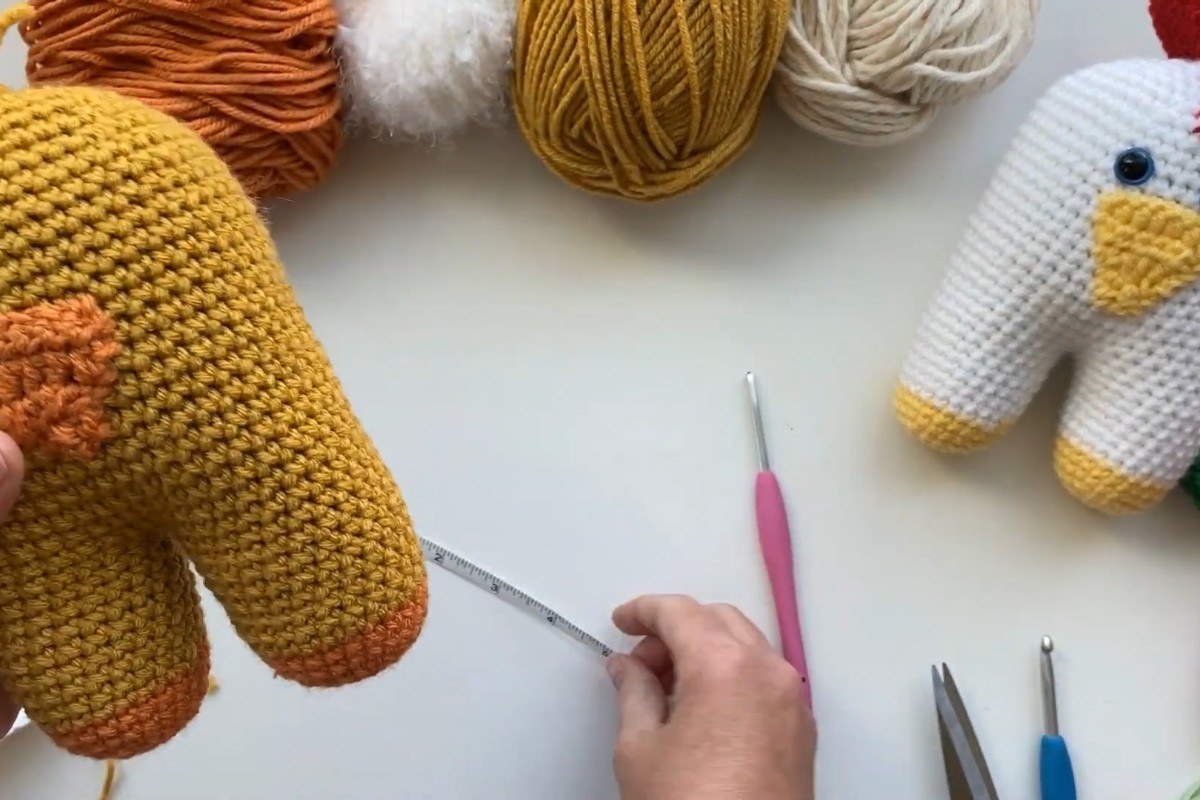 Measuring the finished crochet amigurumi chick with a tape measure