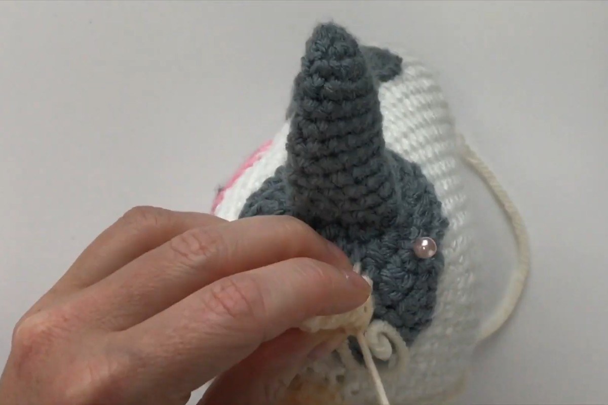 Sewing the final pieces onto the head of the crochet amigurumi cow