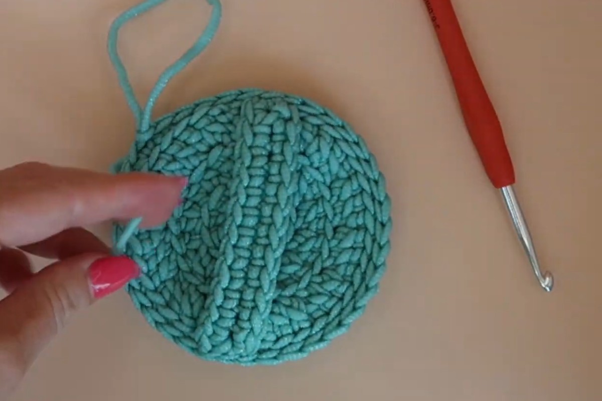 Finished crochet dish scrubby with a handle across the back and a hanging loop