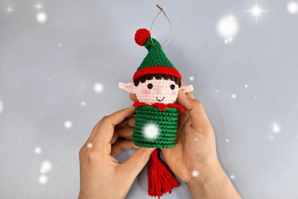 Finished crochet elf wind spinner Christmas ornament with green hat, pointed ears and red yarn tassel