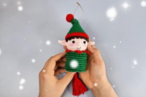 Finished crochet elf wind spinner Christmas ornament with green hat, pointed ears and red yarn tassel