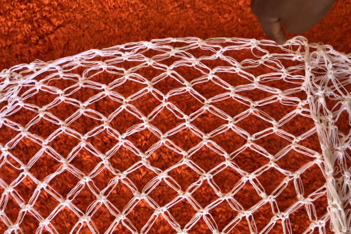 Close-up of the white Solomon stitch mesh of the crochet kimono coverup