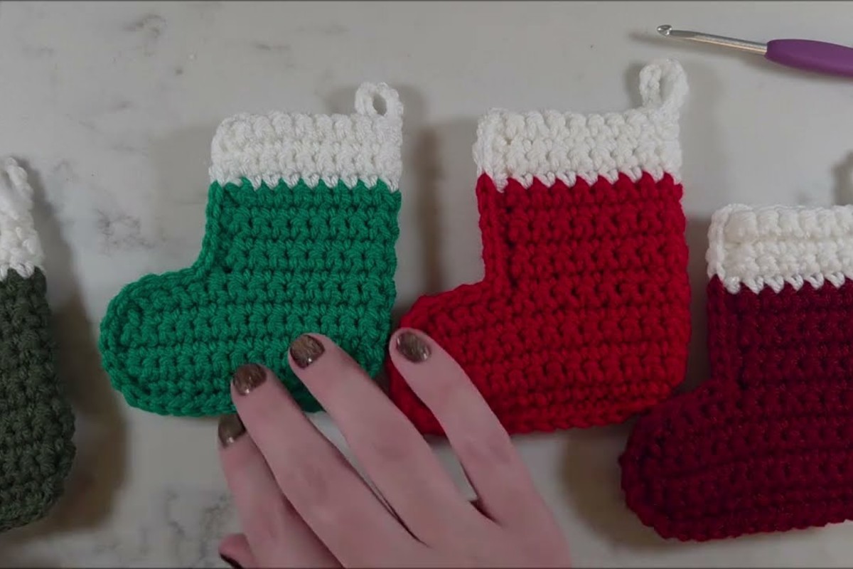 Row of crochet mini stockings with white cuffs and chain hanging loops