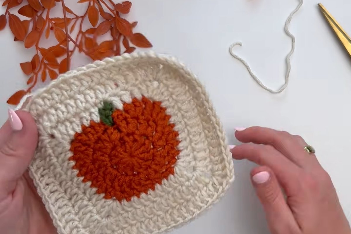 Pumpkin granny square with a green stem and cream border