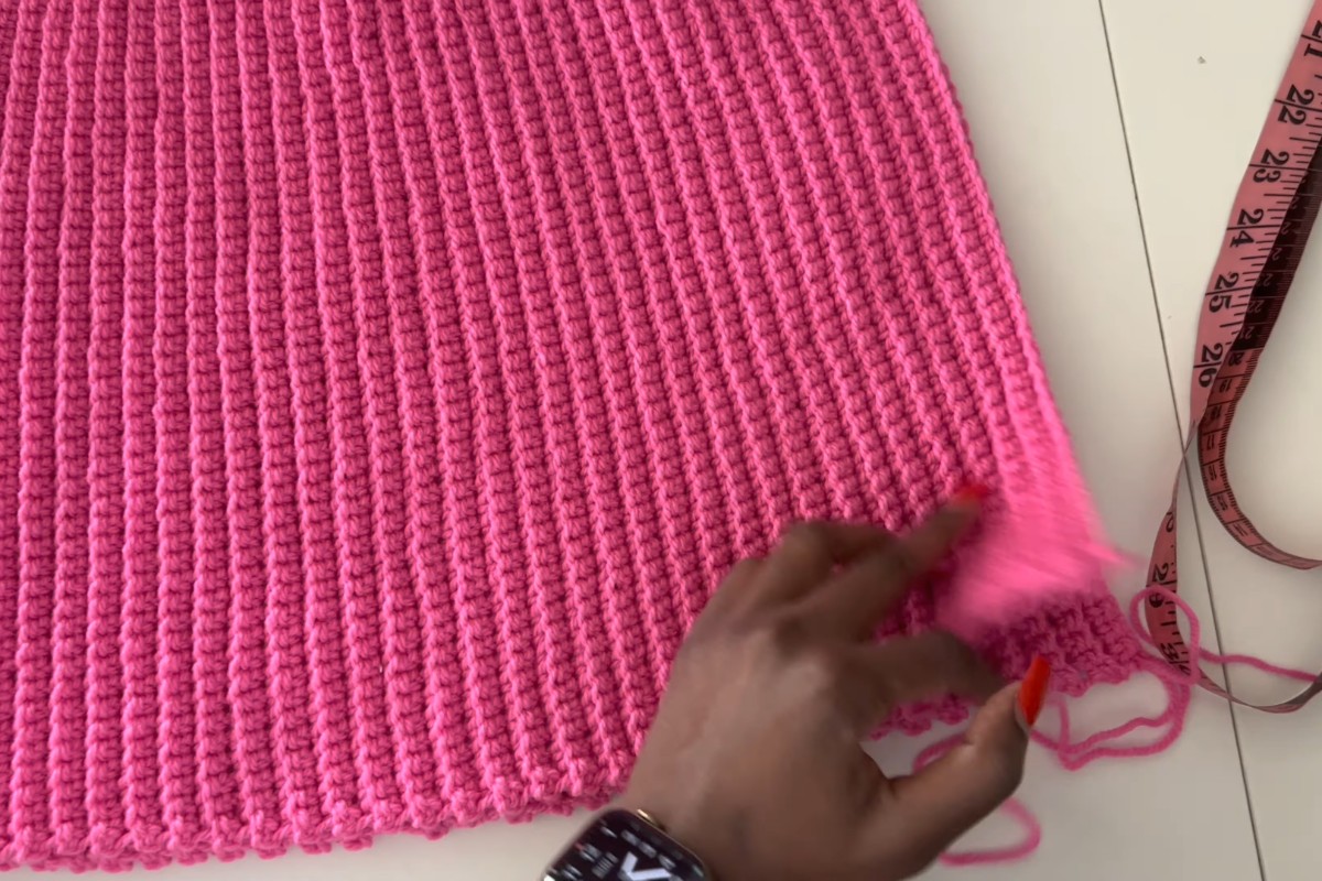 Pink crochet ribbed skirt panel measured against the hips