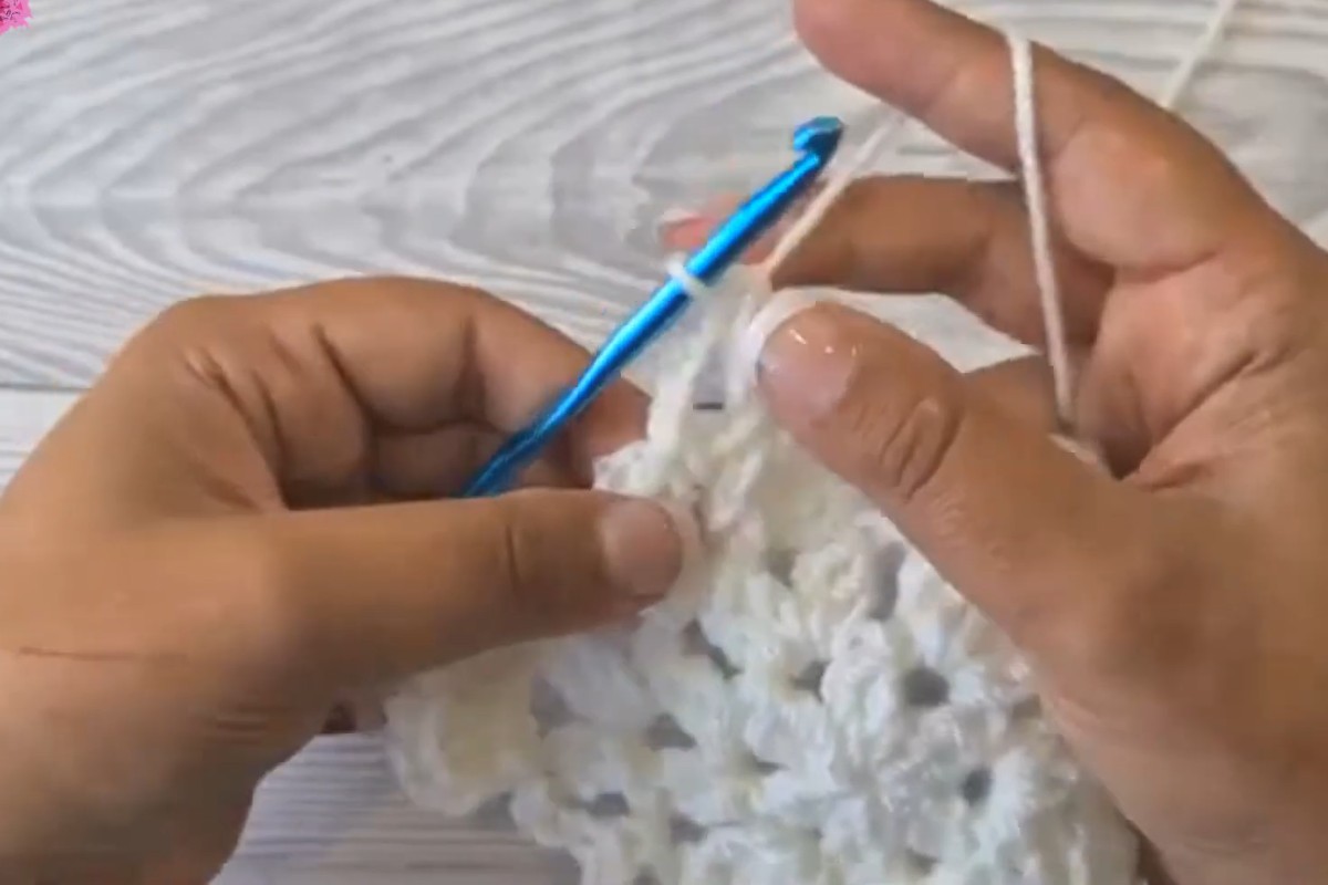 Working the white snowflake center of the granny hexagon motif, left-handed