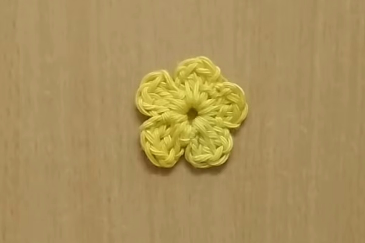 Finished five-petal crochet flower in yellow cotton yarn