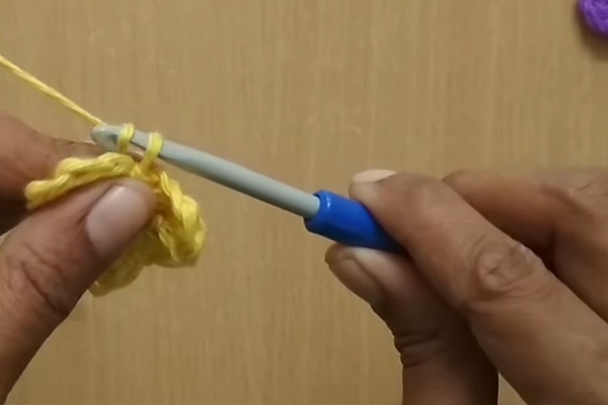 Working the double crochet petals of a simple crochet flower into the center ring