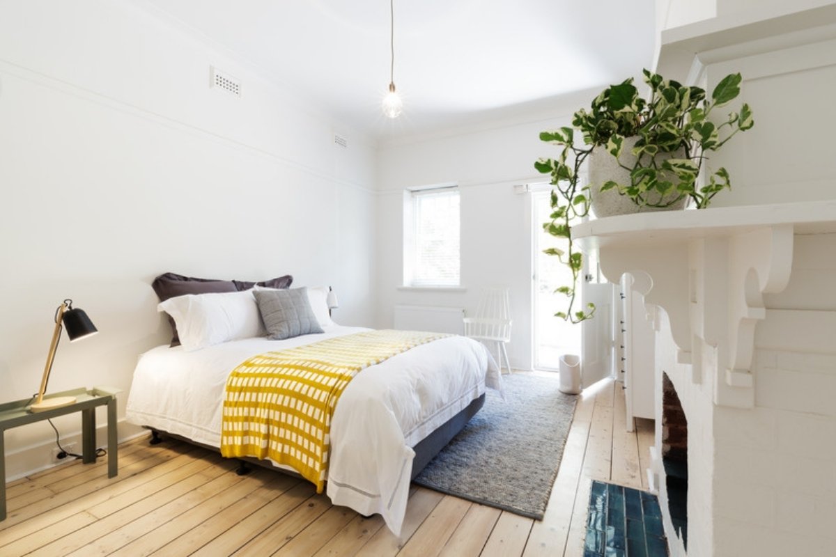 Guest bedroom with fresh white bedding and a yellow throw