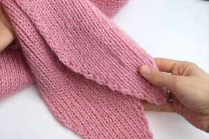 Close-up of the pointed ribbed ties on a pink knit hat-hood
