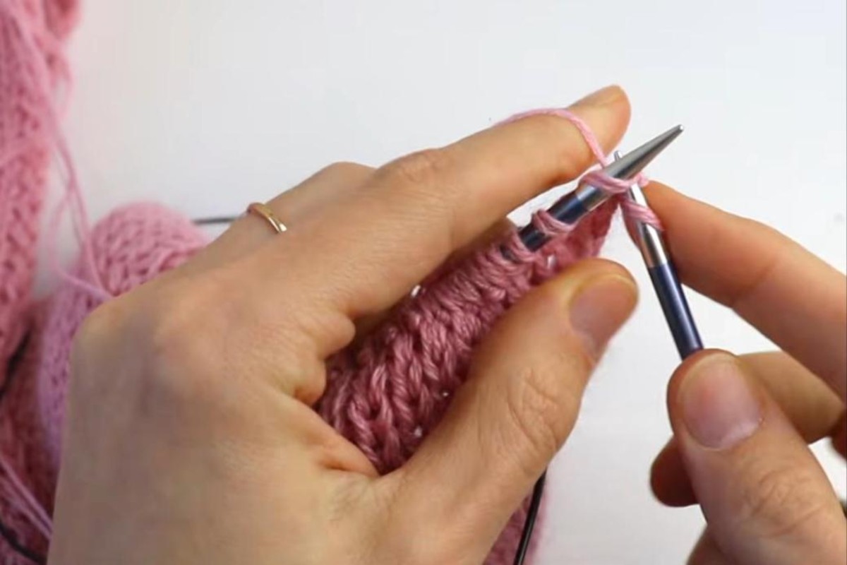 Knitting the hood section of a pink hat-hood on circular needles