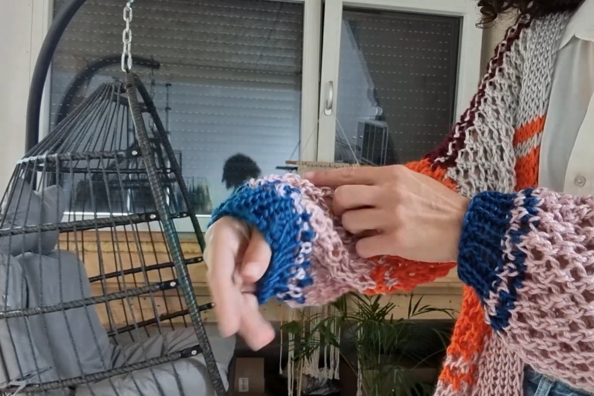 Close-up of the finished Rayee Cardigan showing the striped eyelet sleeve and ribbed cuff