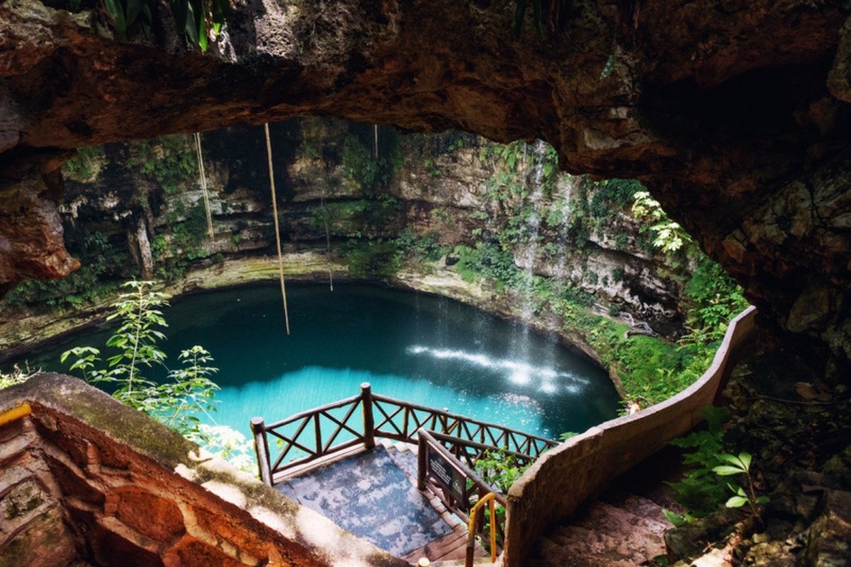 Turquoise cenote surrounded by jungle and vines on the Yucatan Peninsula, Mexico