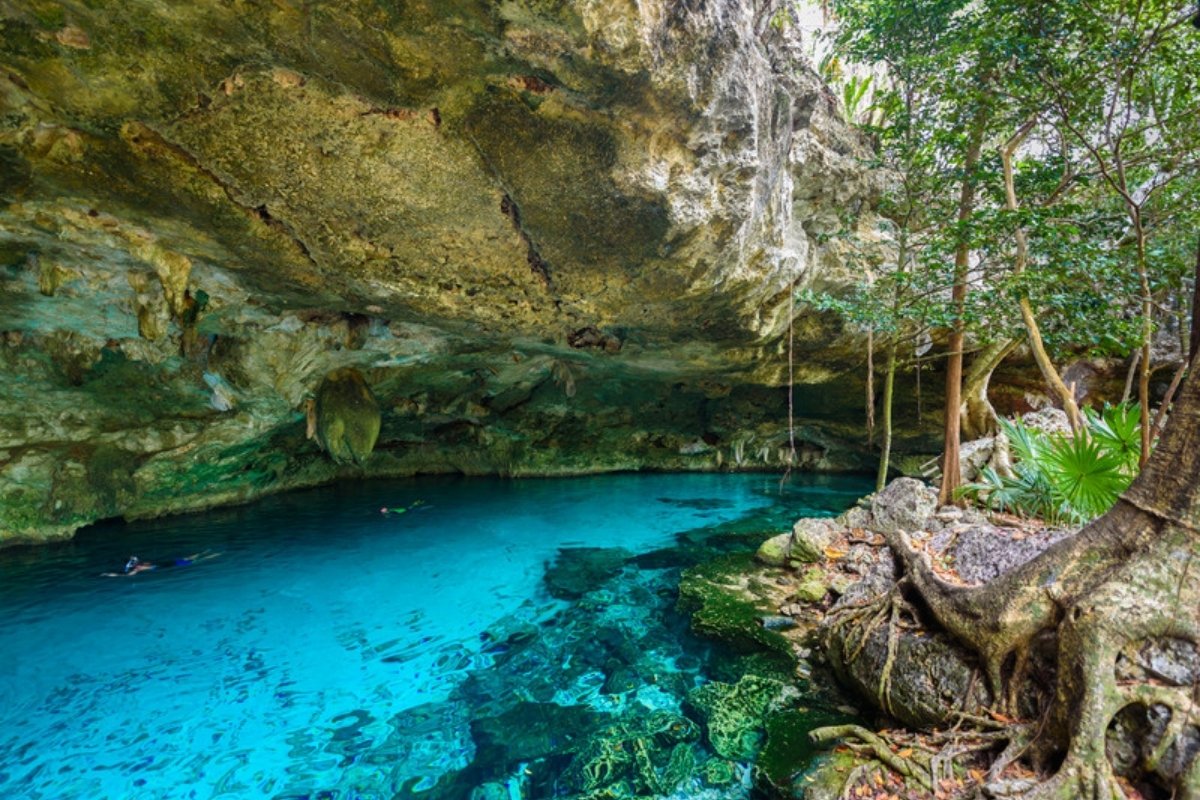Clear blue cenote inside a limestone cave in the Yucatan jungle